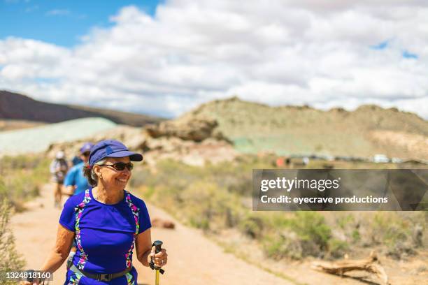 mature adult hispanic female and caucasian male couple hiking in arches national park utah photo series - age progress stock pictures, royalty-free photos & images