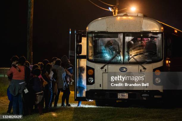Migrants board a bus to be taken to a border patrol processing facility after crossing the Rio Grande into the U.S. On June 21, 2021 in La Joya,...