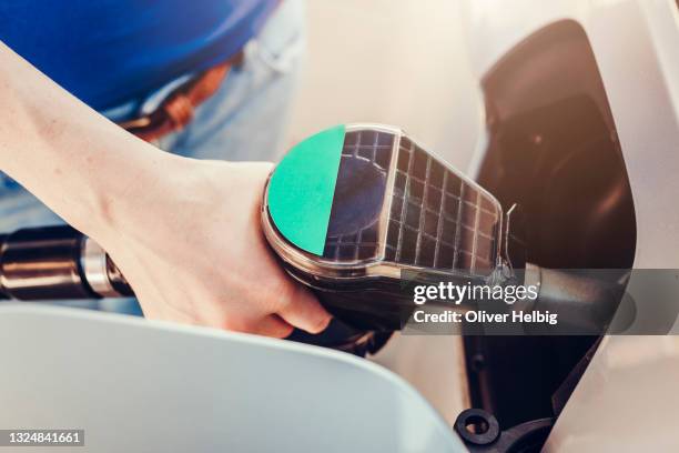 pumping gas at gas pump. closeup of woman pumping gasoline fuel in car at gas station - gasoline pistol stock pictures, royalty-free photos & images