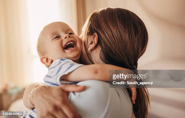 mother hugging her little son - baby clothes bildbanksfoton och bilder