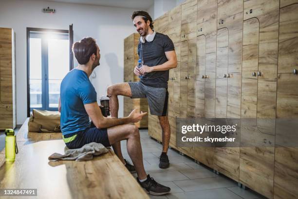 happy male athletes talking at gym's locker room. - locker room stock pictures, royalty-free photos & images