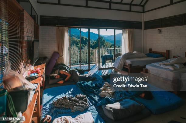 the morning after chinese male hang over oversleeping in bedroom with messy blankets - messy house after party stock pictures, royalty-free photos & images