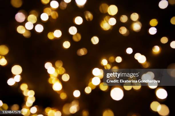gold sparkling sequins on a black isolated background. - christmas background abstract gold stock pictures, royalty-free photos & images