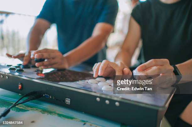 2 asian chinese male playing retro style video game during weekend social gathering - retro games stockfoto's en -beelden