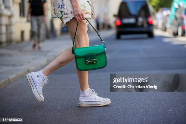 Lisa Banholzer is seen wearing shirt with print Vans X Zodiak, Shorts Levis, shoes Converse, green bag Gucci on June 21, 2021 in Berlin, Germany.