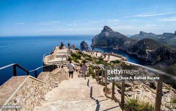 people at a large viewpoint (es colomer) by the sea on the coast of formentor, majorca island. - cabo formentor - fotografias e filmes do acervo