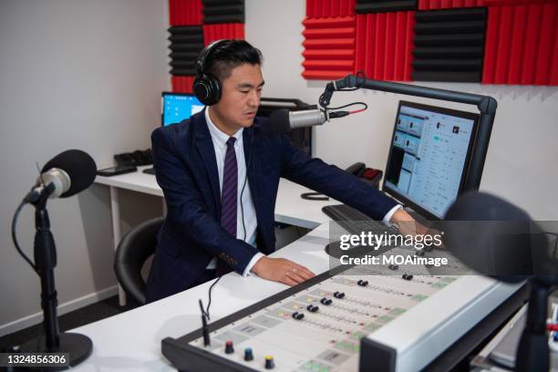 young asian male host in formal attire in broadcasting studio - radio host stock pictures, royalty-free photos & images