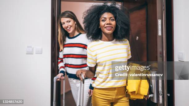 female friends arriving in the hotel and opening their room - abrir a porta sair imagens e fotografias de stock