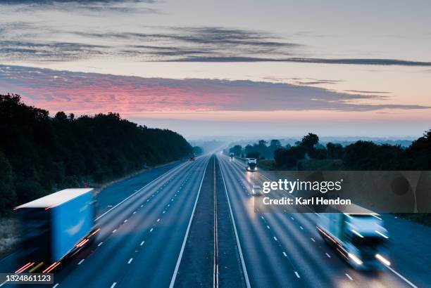 an elevated view of a uk motorway at sunrise - stock photo - shipping logistics stock pictures, royalty-free photos & images