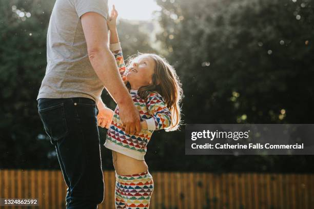 cute little girl reaches up to her father - little kids belly imagens e fotografias de stock