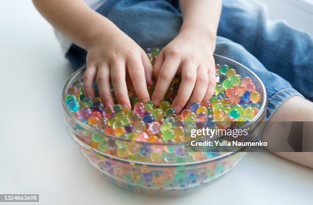 a child plays with hydrogel beads - girl and shower gel stock pictures, royalty-free photos & images