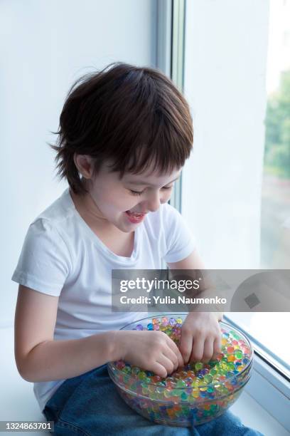 a child plays with hydrogel beads - girl and shower gel stock pictures, royalty-free photos & images