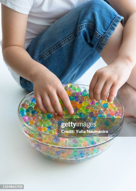 a child plays with hydrogel beads - girl and shower gel stock pictures, royalty-free photos & images