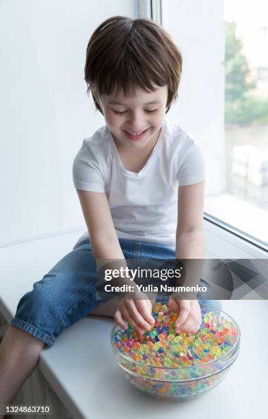 a child plays with hydrogel beads - girl and shower gel stock pictures, royalty-free photos & images
