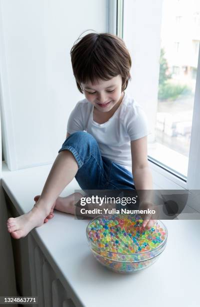 a child plays with hydrogel beads - girl and shower gel stock pictures, royalty-free photos & images