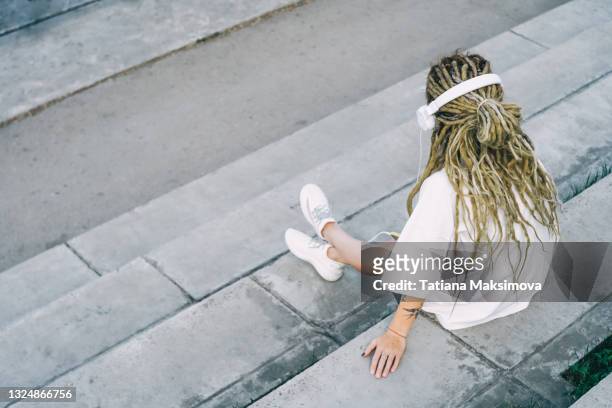 back view of young woman with dreadlocks in the city stairs. - rastazopf stock-fotos und bilder