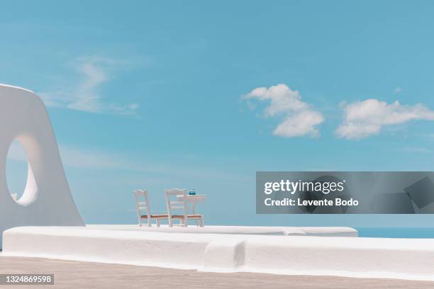 greece santorini island, caldera view with chairs and table. famous travel destination and scenery. summer vacation, romantic couple honeymoon holiday concept - mediterranean sea ストックフォトと画像