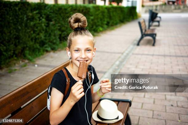 teenager pretty girl eating ice crem outdoors - kid eating ice cream stockfoto's en -beelden