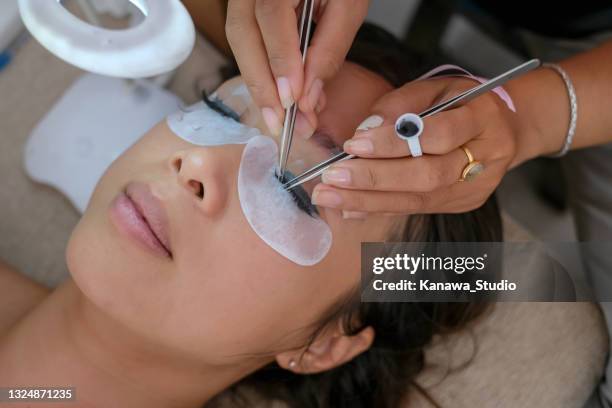 hermosa mujer conseguir servicio a domicilio extensión de pestañas - eyelash fotografías e imágenes de stock