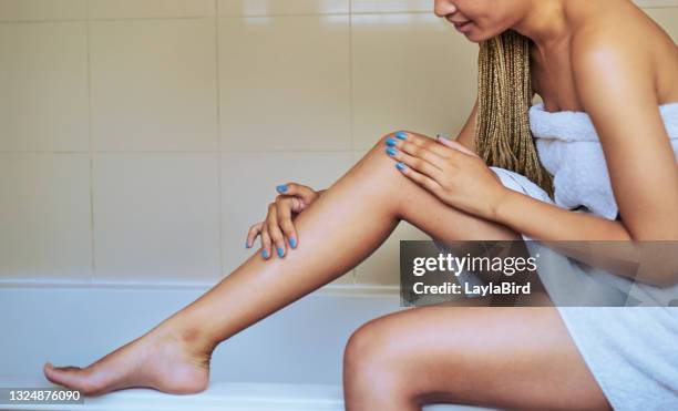 foto de una joven hidratando sus piernas después de afeitarse - waxing hair removal fotografías e imágenes de stock