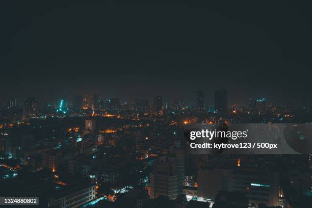 high angle view of illuminated buildings against sky at night,hanoi,vietnam - hanoi night stock-fotos und bilder