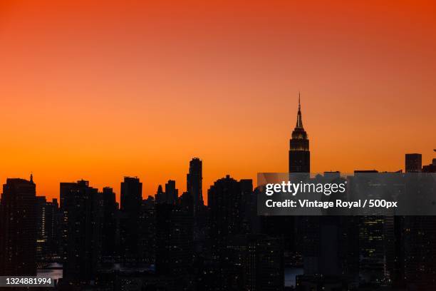 silhouette of buildings against sky during sunset,long island city,united states,usa - long island city stockfoto's en -beelden