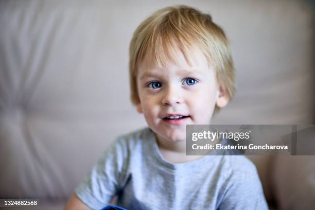 portrait of a small blond boy 2-3 years old at home watching tv - 2 3 years foto e immagini stock