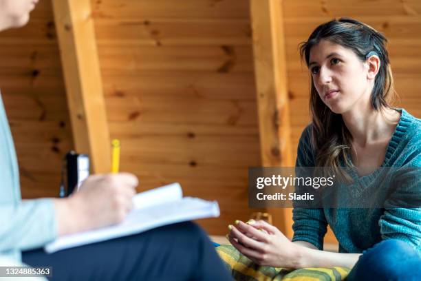 a young woman in a session with a psychologist - cochlear implant stock pictures, royalty-free photos & images