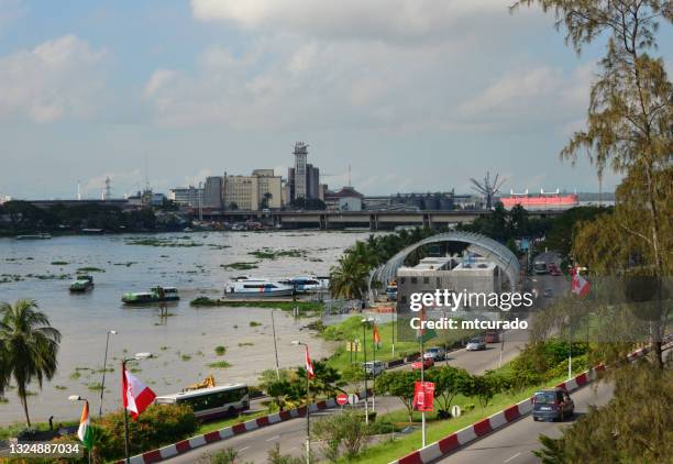 boulevard de gaulle und die bootsstation plateau an der lagune von ebrié - blick auf die houphouét-boigny-brücke und die gma-mehlmühle in treichville, abidjan, elfenbeinküste - abidjan stock-fotos und bilder