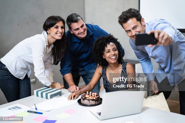 business colleagues taking a selfie during birthday party at work - jubileum werk stockfoto's en -beelden