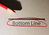 Bottom Line text circled in red pencil on textured paper