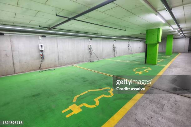 parking garage with charging stations for electric cars - autobergplaats stockfoto's en -beelden