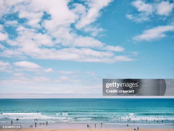 views over fistral beach, newquay, cornwall on a bright sunny june day, people surfing and enjoying the beach. - newquay stock pictures, royalty-free photos & images