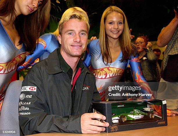 Formula 1 race car driver Eddie Irvine poses with models July 11, 2001 at Hamleys toy store in London, England during the launch of Hot Wheels''...