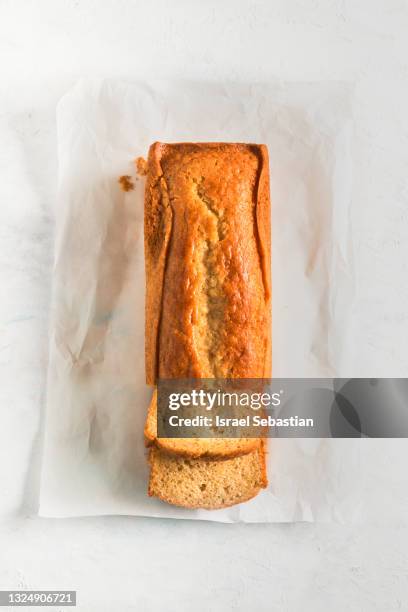 view from top of a homemade sponge cake fresh from the oven and cut into pieces on a white wooden table - yellow cake stock pictures, royalty-free photos & images