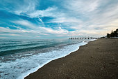 Sandy beach and a wooden pier on Costa del Sol in resort city of Marbella in Spain