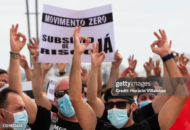 Members of Portuguese security forces wear protective masks and make the Zero gesture as they march demanding better working conditions in Praça do...