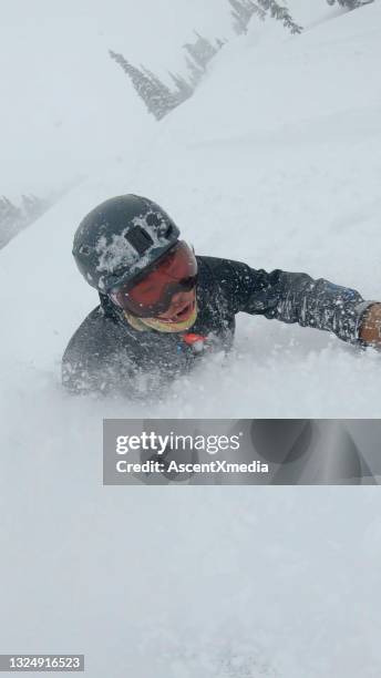 skier descends snow slope through deep powder snow - extreem skiën stockfoto's en -beelden