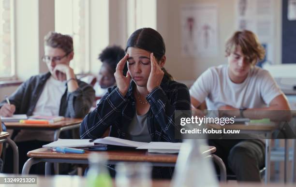 foto de un estudiante luchando con las tareas escolares en un aula - frustración fotografías e imágenes de stock