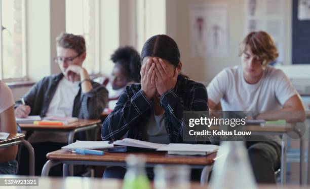 schuss eines schülers, der mit schularbeiten in einem klassenzimmer kämpft - anxiety man stock-fotos und bilder