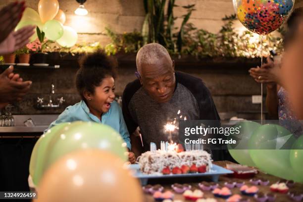 großvater und enkelin feiern gemeinsam geburtstag zu hause - black balloon stock-fotos und bilder