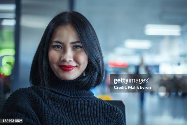 retrato de una mujer asiática esperando un vuelo en la terminal del aeropuerto - departure board front on fotografías e imágenes de stock