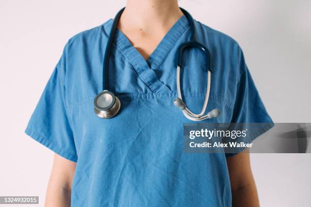 female doctor in blue surgical scrubs with stethoscope - cara oculta fotografías e imágenes de stock