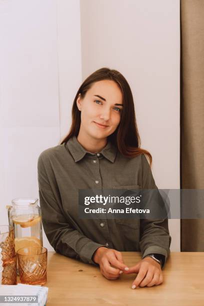 beautiful girl stands behind the counter - beige blouse stockfoto's en -beelden