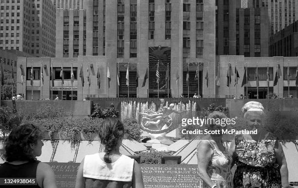 View of two women posing for a picture , as others take in the sights outside Rockefeller Center, New York, New York, July 18, 1987. Visible is 30...