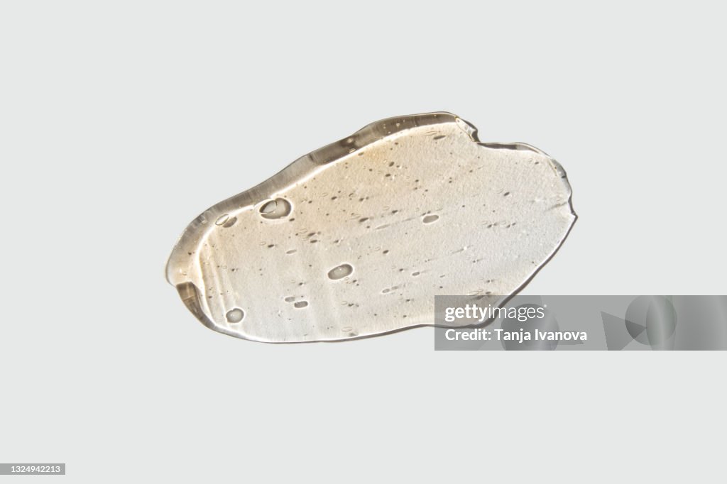 Transparent smear of orange Gel on white background. Liquid yellow wax or sugar paste for depilation. The concept of depilation, waxing, sugaring smooth skin without hair, banner