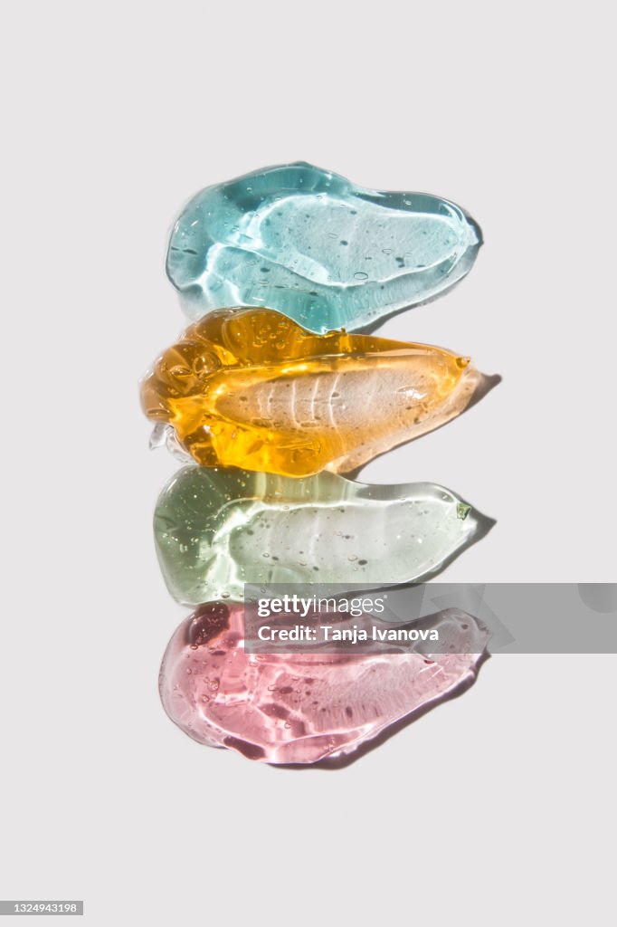 Transparent smears of colorful Gel on white background. Flat lay, top view