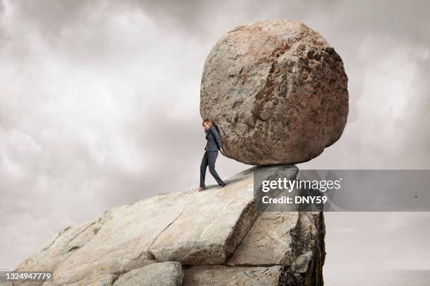 woman pushes large boulder off a cliff - colina acima imagens e fotografias de stock