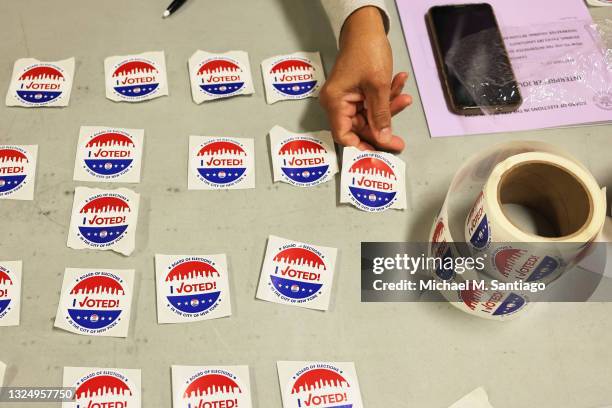 Poll worker lays out "I Voted" stickers on a table during the Primary Election Day at P.S. 249 The Caton School on June 22, 2021 in the Flatbush...