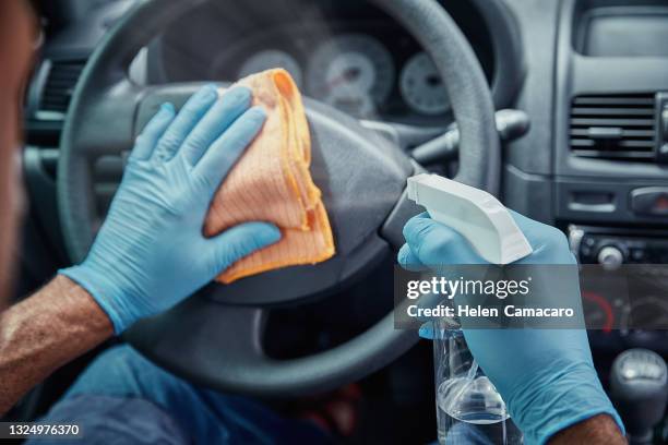 close up of hands with gloves applying spray alcohol and cleaning interior car - epidemie stock pictures, royalty-free photos & images